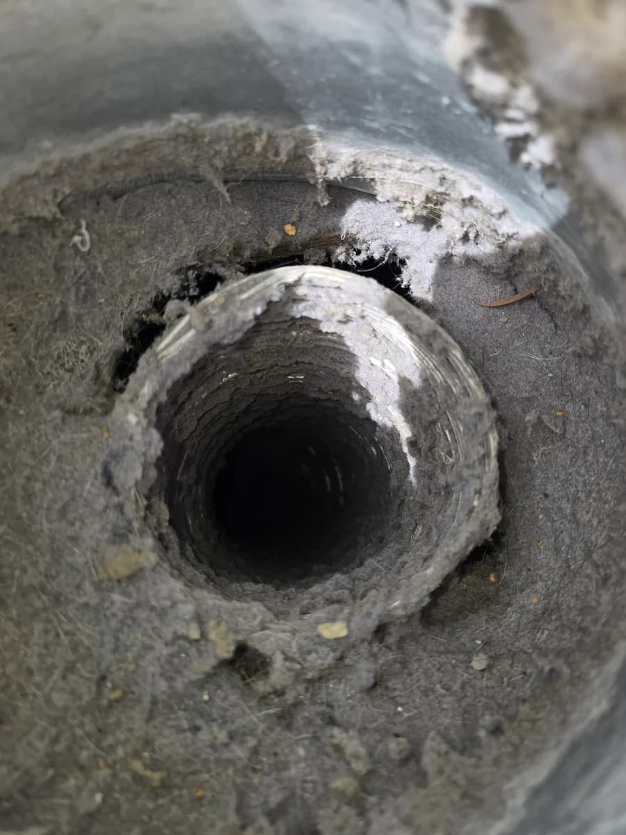 Dryer vent opening packed with lint before cleaning
