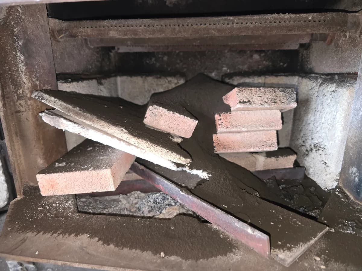 Debris and soot inside a wood stove firebox